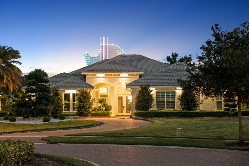 Elegant residential house with well-maintained landscaping and a view of a distinctive city skyline.