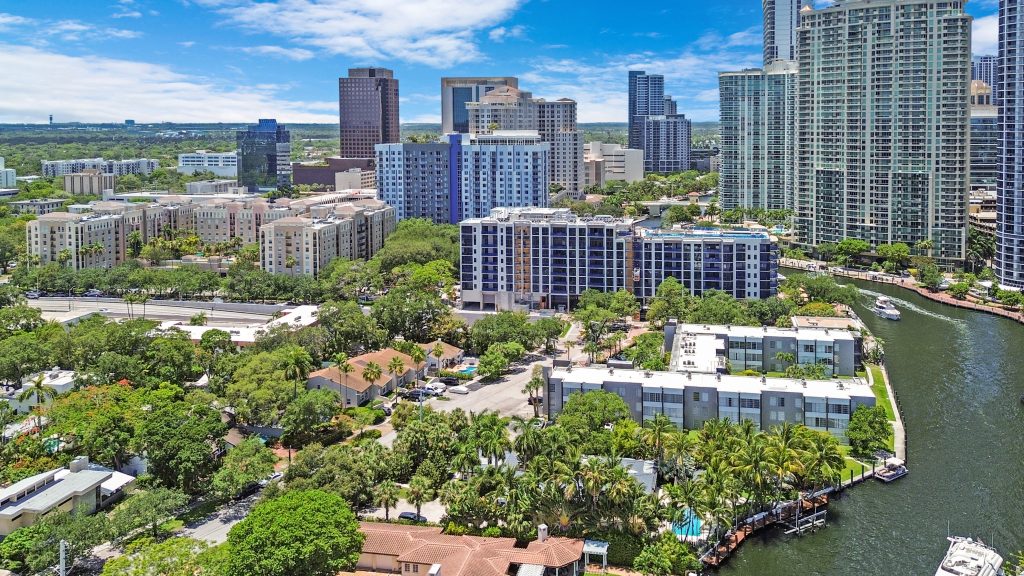 Brightly lit Miami cityscape with high-rise buildings and waterway, showcasing urban development and.