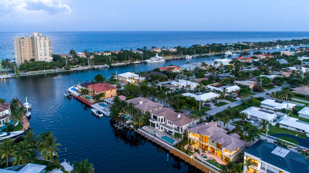 Waterfront luxury homes with boat docks in a tropical coastal neighborhood.