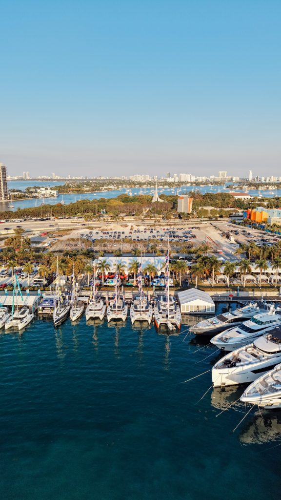 Luxury yachts docked at Miami marina with city skyline in background.