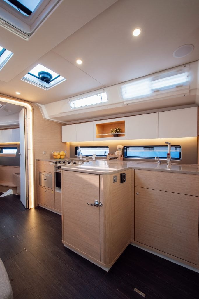 Contemporary yacht kitchen with natural wood cabinets and skylights.