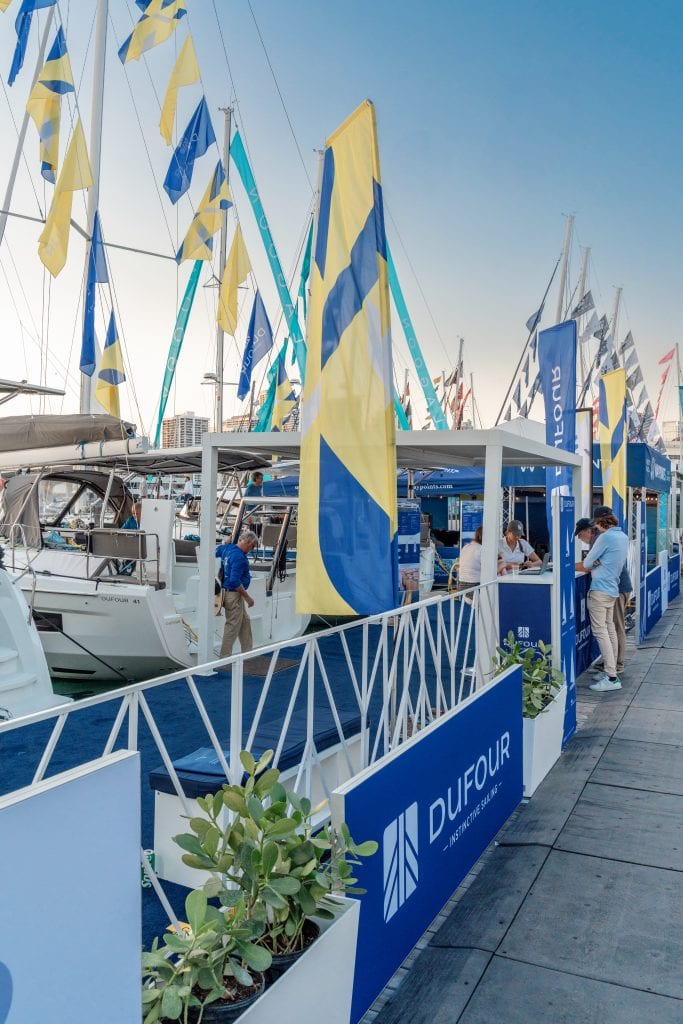 Yachts and flags at Miami Boat Show with AccuTour branding.