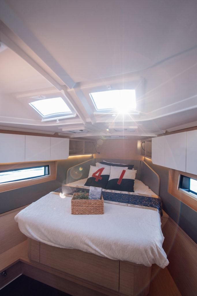 Cozy yacht bedroom with skylights and modern decor.