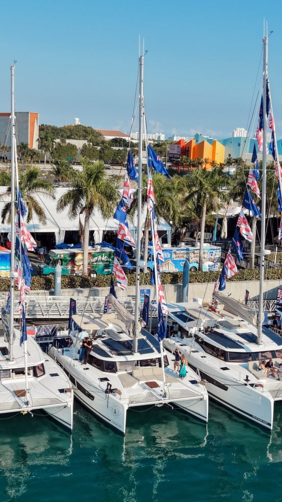 Luxury yachts docked at Miami marina during boat show event.