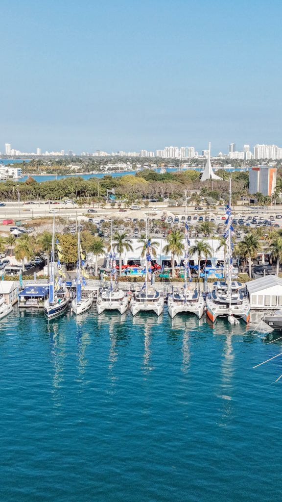 Marina with yachts and Miami skyline in the background.