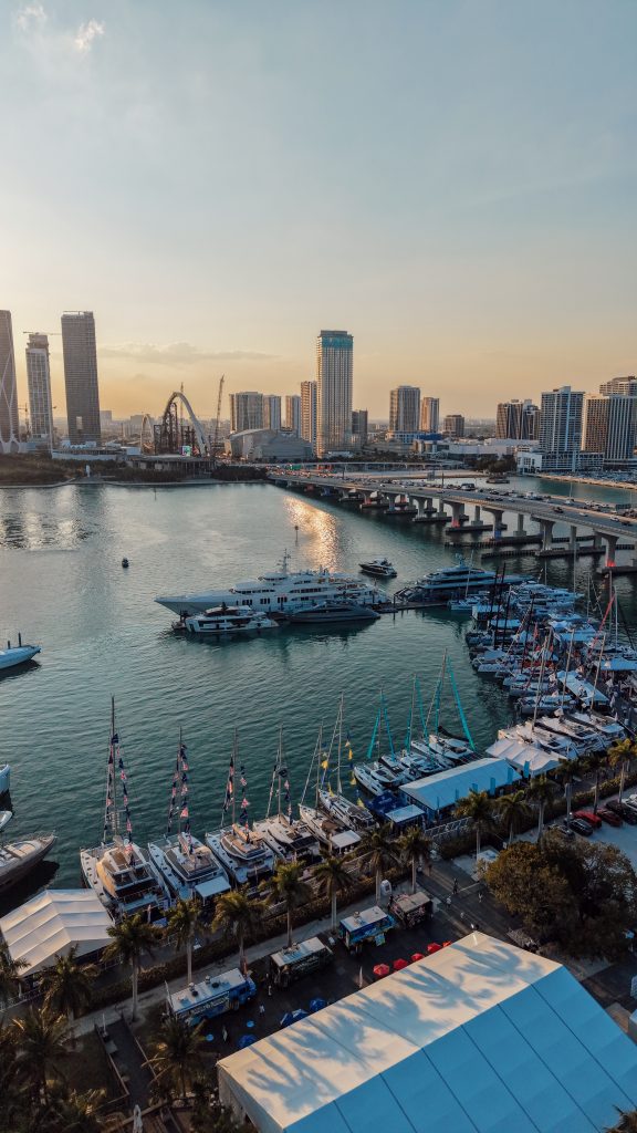 Miami yacht harbor with boats and city skyline at sunset.
