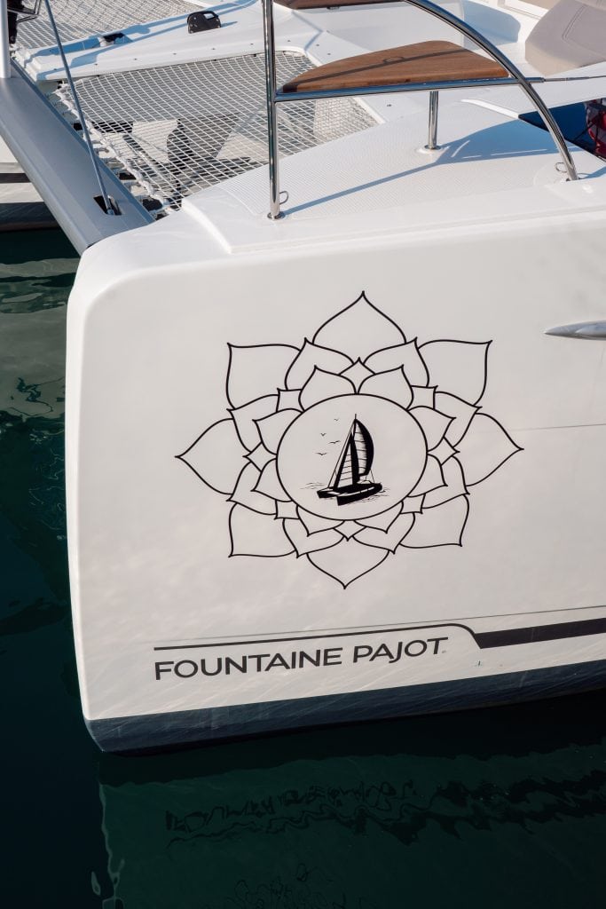 Fountaine Pajot sailboat logo with sailboat and lotus design.
