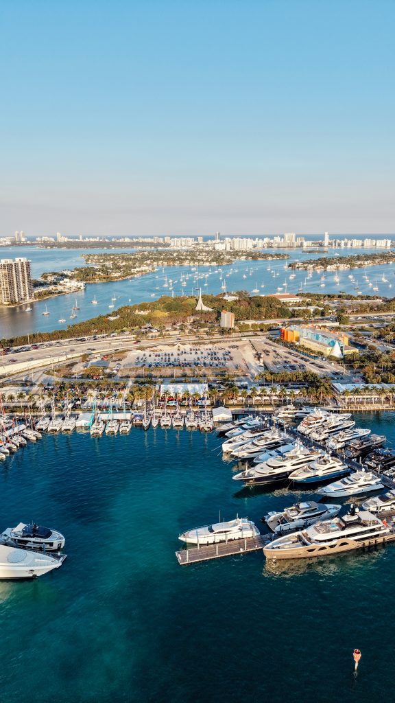 Aerial view of Miami yacht marina with boats and city skyline.