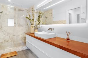 Elegant modern bathroom featuring marble walls, a sleek white sink, and minimalist decor.