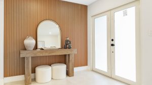Entryway with wooden wall paneling, mirror, and decorative vases.
