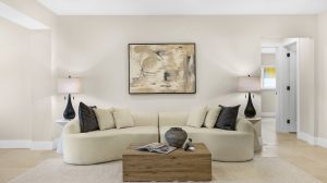 Living room with beige sofa, black and white pillows, and contemporary artwork.