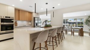 Modern kitchen with island, bar stools, and dining space in a bright, open-concept home. Perfect for.