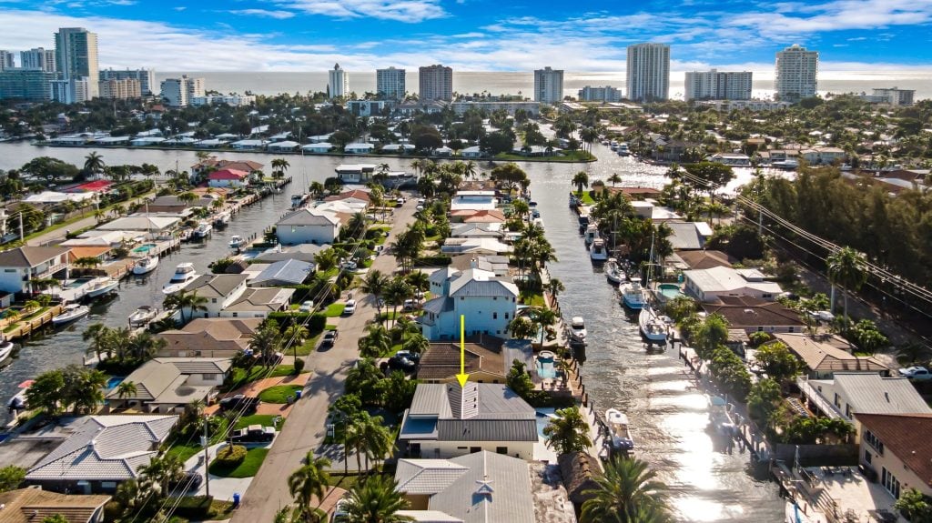 Drone aerial shot of a coastal city with waterways and high-rise buildings.