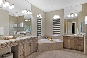 Elegant bathroom featuring dual vanities, a large bathtub, and modern fixtures for a spa-like experi.