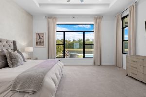 Spacious bedroom featuring a large window with scenic lake views and natural light, perfect for rela.