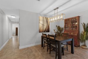 Contemporary dining room with wooden table, chairs, and decorative plants.