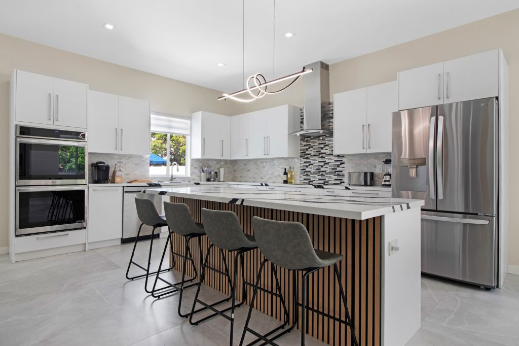 Contemporary kitchen with white cabinets, island, and stainless steel appliances.
