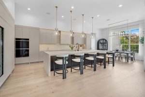 Modern kitchen with island, pendant lighting, and dining space in a bright, open-concept home.