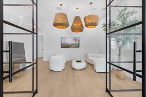 Bright office lounge featuring glass doors, contemporary furniture, and warm lighting for a welcomin.