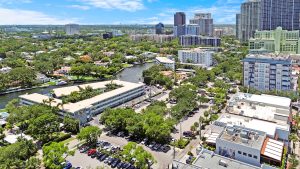 Downtown Orlando cityscape featuring high-rise buildings, green parks, and a waterway under a clear.