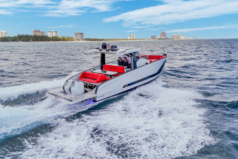 Luxury motor yacht cruising on open water with sleek white exterior and vibrant red seating.