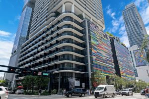 Contemporary city building with colorful exterior and curved balconies in downtown area.