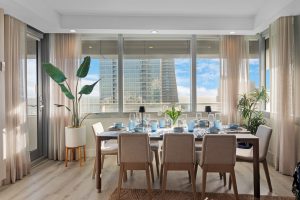 Elegant dining room with large windows overlooking cityscape and natural light.