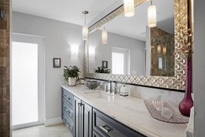Contemporary bathroom with sleek vanity, large mirror, and stylish lighting fixtures.