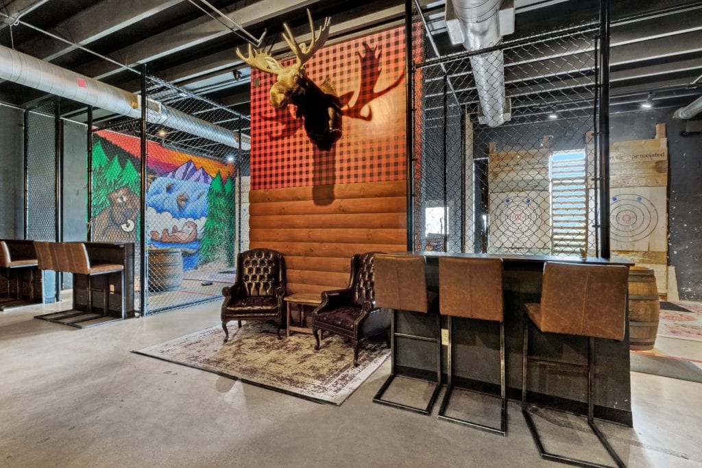 Contemporary industrial lounge featuring rustic accents, leather chairs, and decorative wall art.