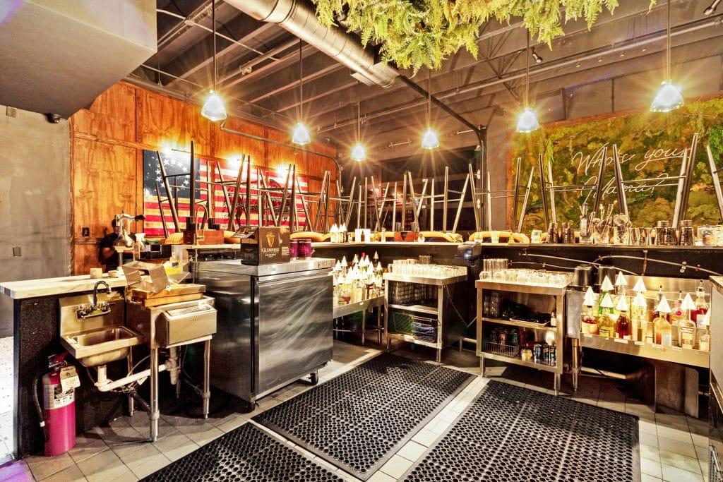 Industrial kitchen with stainless steel equipment, bright lighting, and American flag wall art for a.