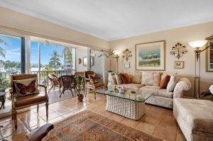 Spacious living room with large windows overlooking a tropical balcony.