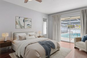 Bright bedroom with pool view, modern decor, and sliding glass door at AccuTour.com.