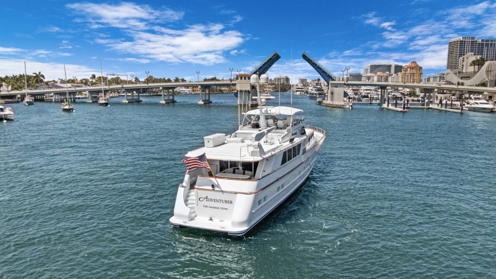 Luxury yacht cruising on calm marina waters with city skyline and clear blue sky, showcasing premium.
