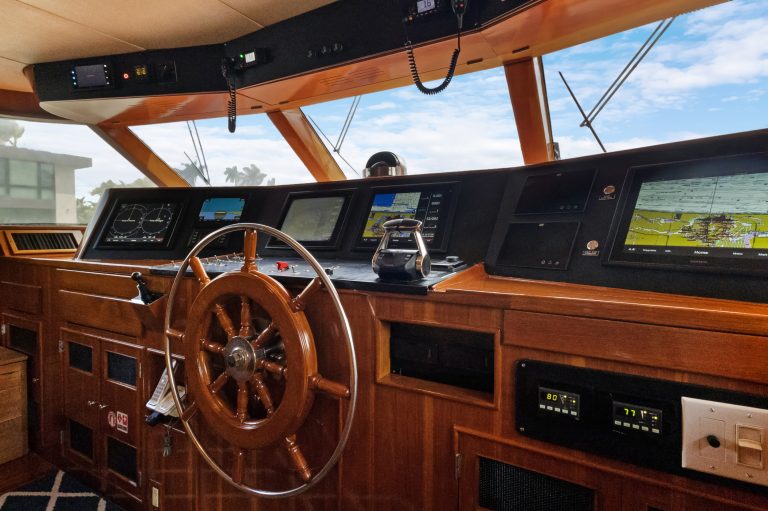 Modern yacht bridge with navigation screens and wooden interior.
