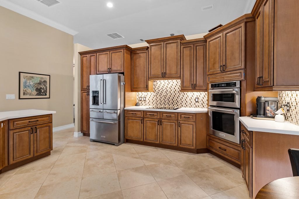 Spacious kitchen with stainless steel appliances and wooden cabinetry.