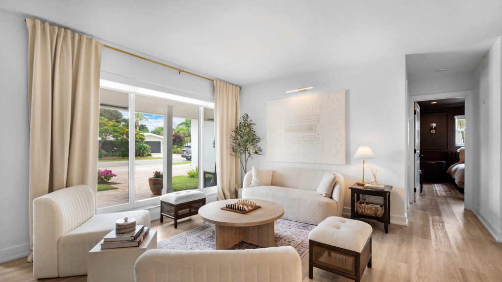 Spacious living room with large window, beige curtains, and modern furniture.
