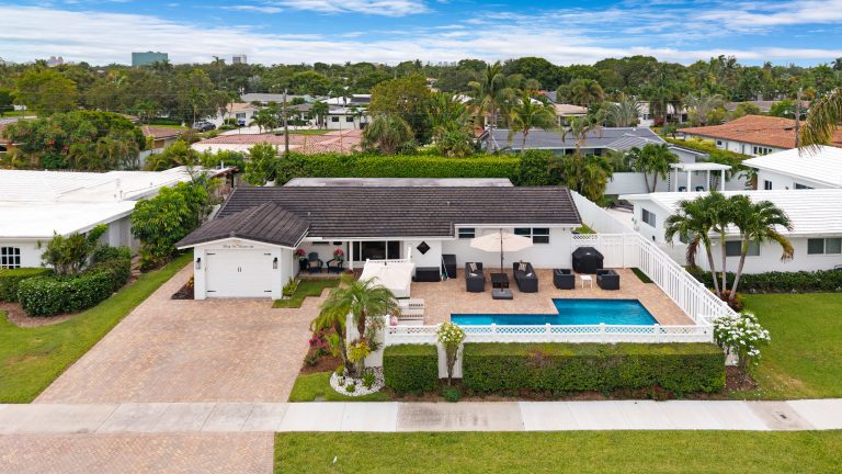 Aerial view of a stylish backyard with a swimming pool and outdoor seating area.