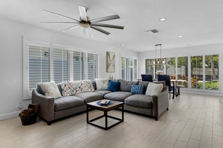 Spacious living room with large windows, white walls, and contemporary furniture.