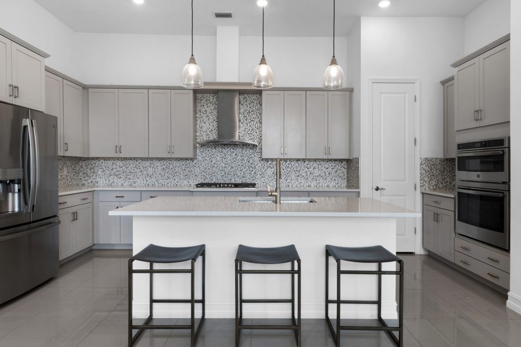 Contemporary kitchen with island, pendant lighting, and stainless steel appliances.