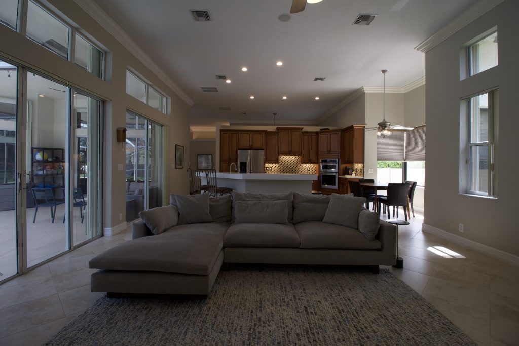 Bright living room with large windows and open kitchen area.
