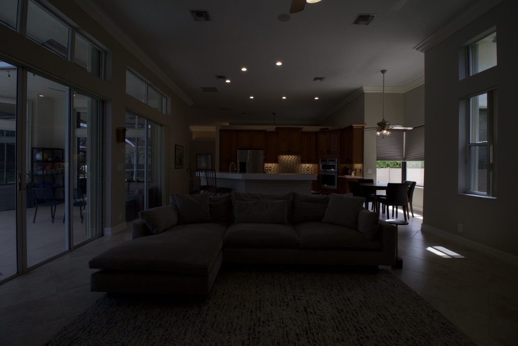 Bright living room with large windows and open kitchen area.