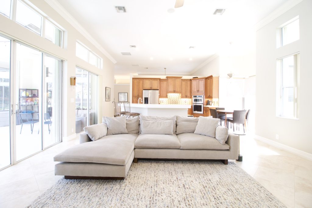 Spacious living room with large windows and open kitchen area.