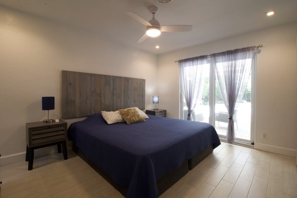 Bright bedroom with large window and minimalist decor for real estate photography.