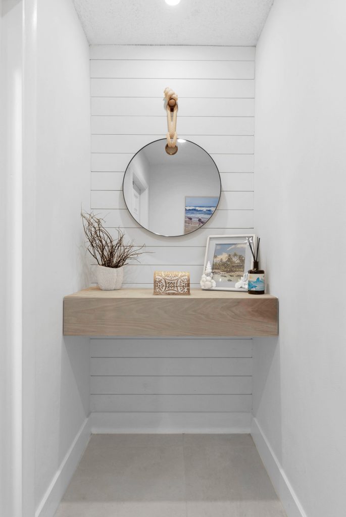 Minimalist entryway with mirror, decor, and coastal accents.