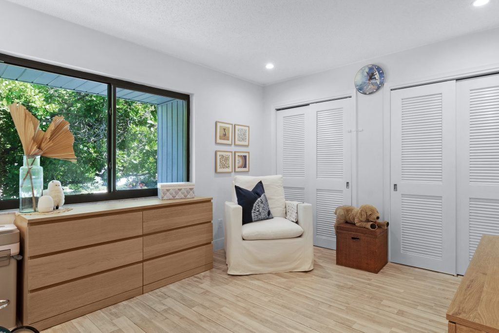 Bright living room with large window, white walls, and minimalist decor.
