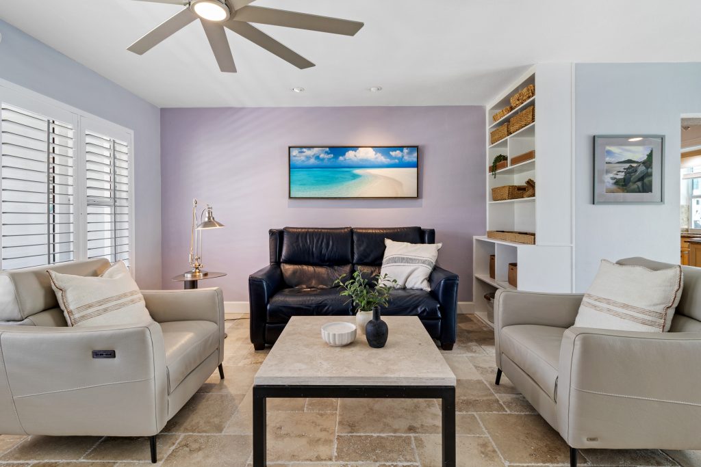 Cozy living room with beach-themed wall art and comfortable sofas.