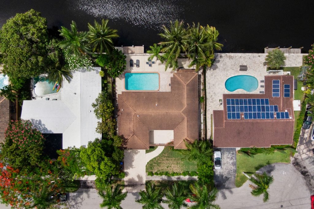 Aerial view of waterfront homes with pools and lush greenery in Fort Lauderdale.