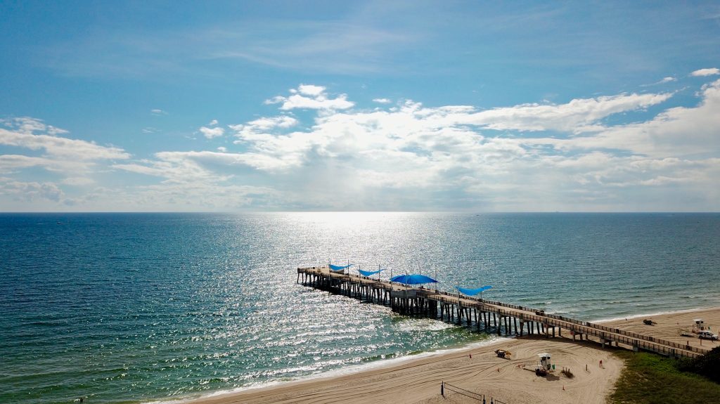 Scenic view of Pompano Beach pier and ocean under blue sky.