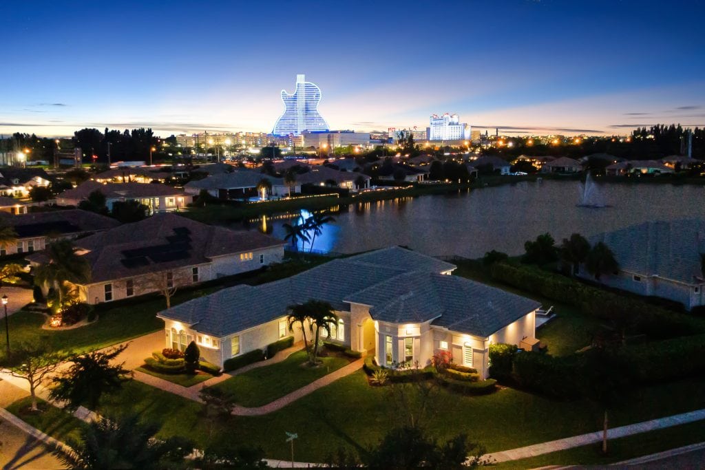 City skyline with illuminated buildings and residential neighborhood at dusk.