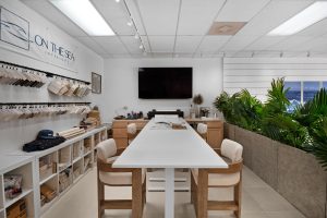 Contemporary conference room with white table and chairs, large TV, and indoor plants.